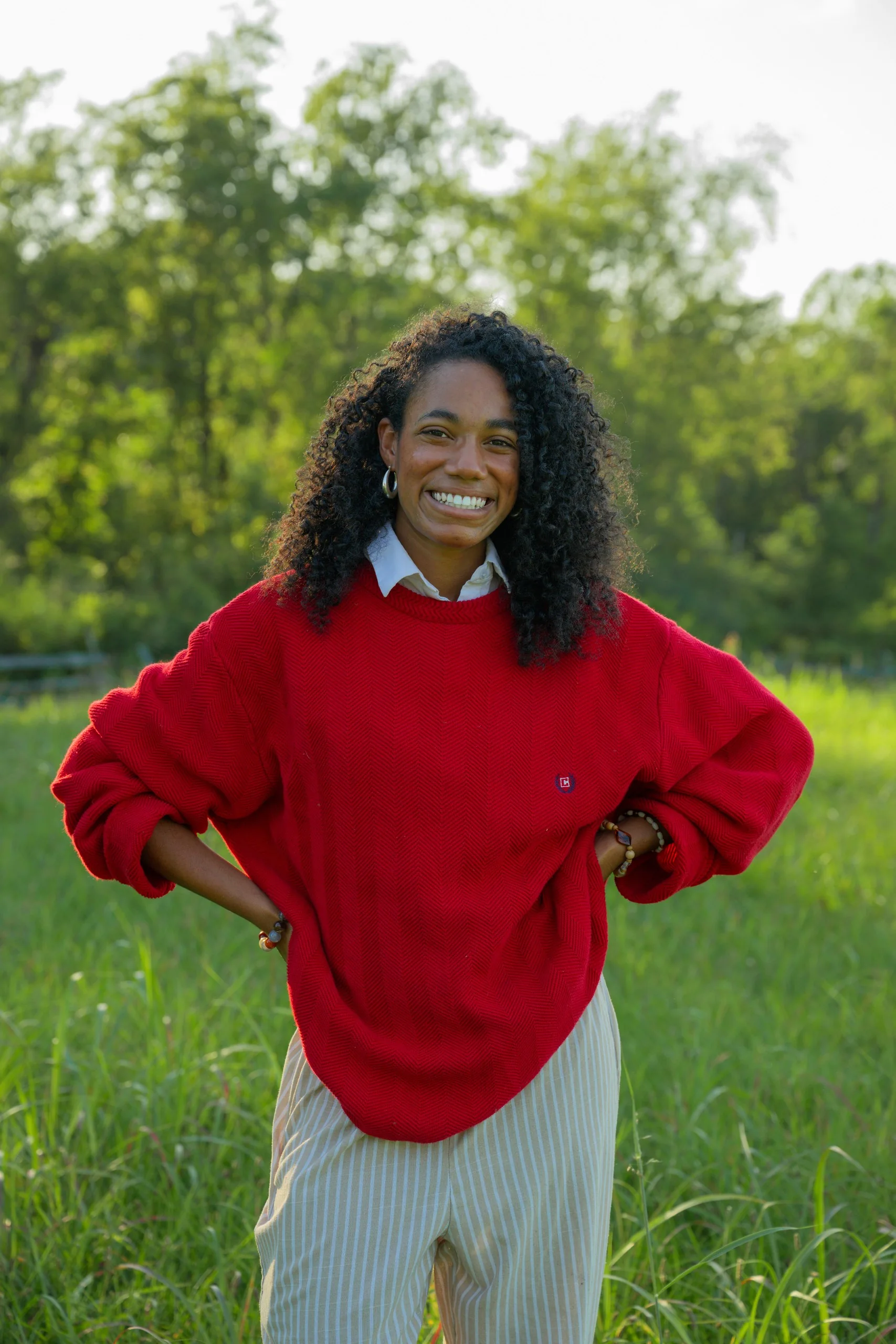 Anna, Idio’s founder, wearing a red sweater in a field.