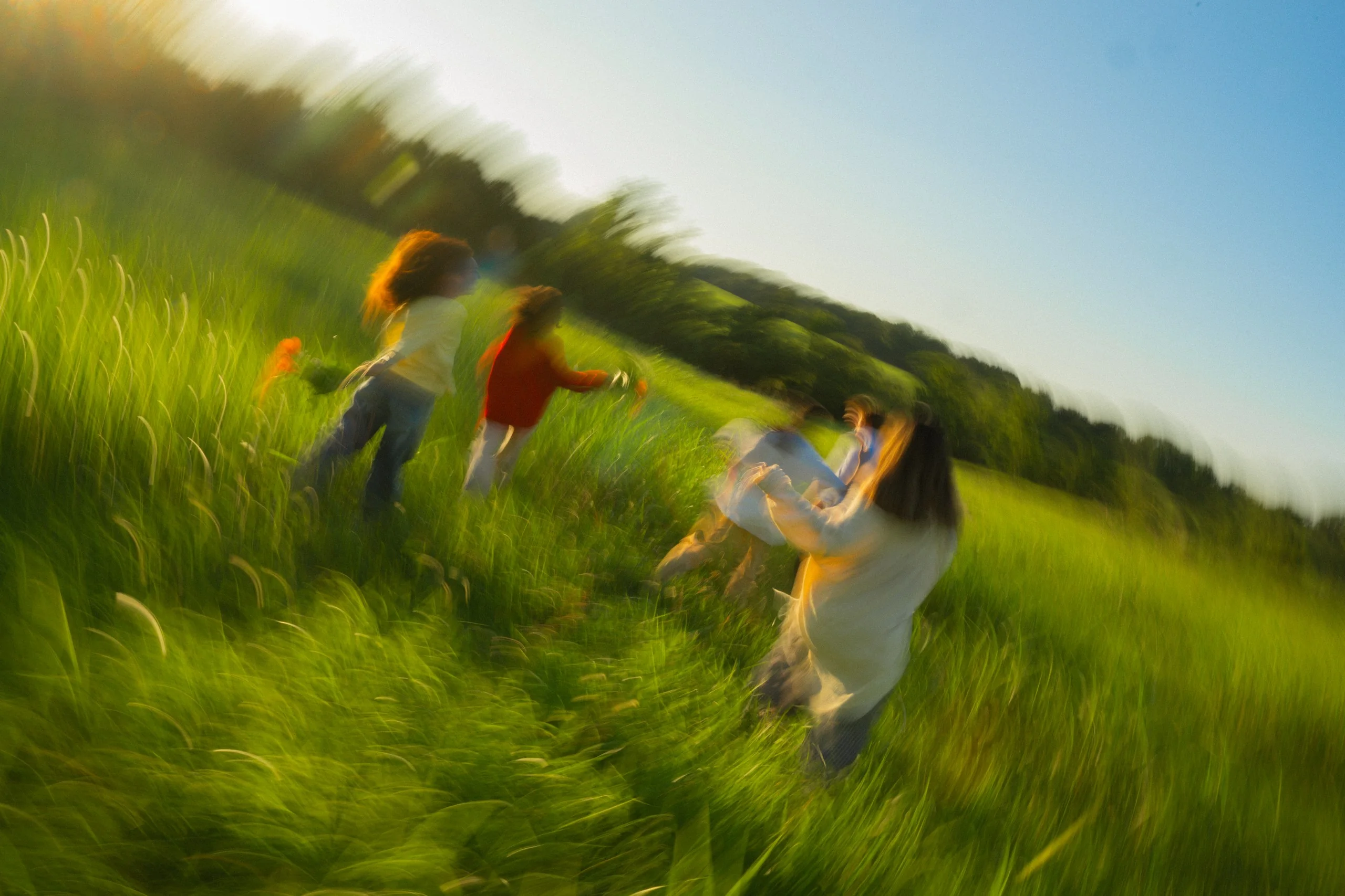 Friends running through a sunlit field.
